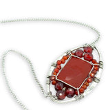 Red jasper tile surrounded by red and orange cubic zirconia gemstones in a hammered sterling silver pendant necklace