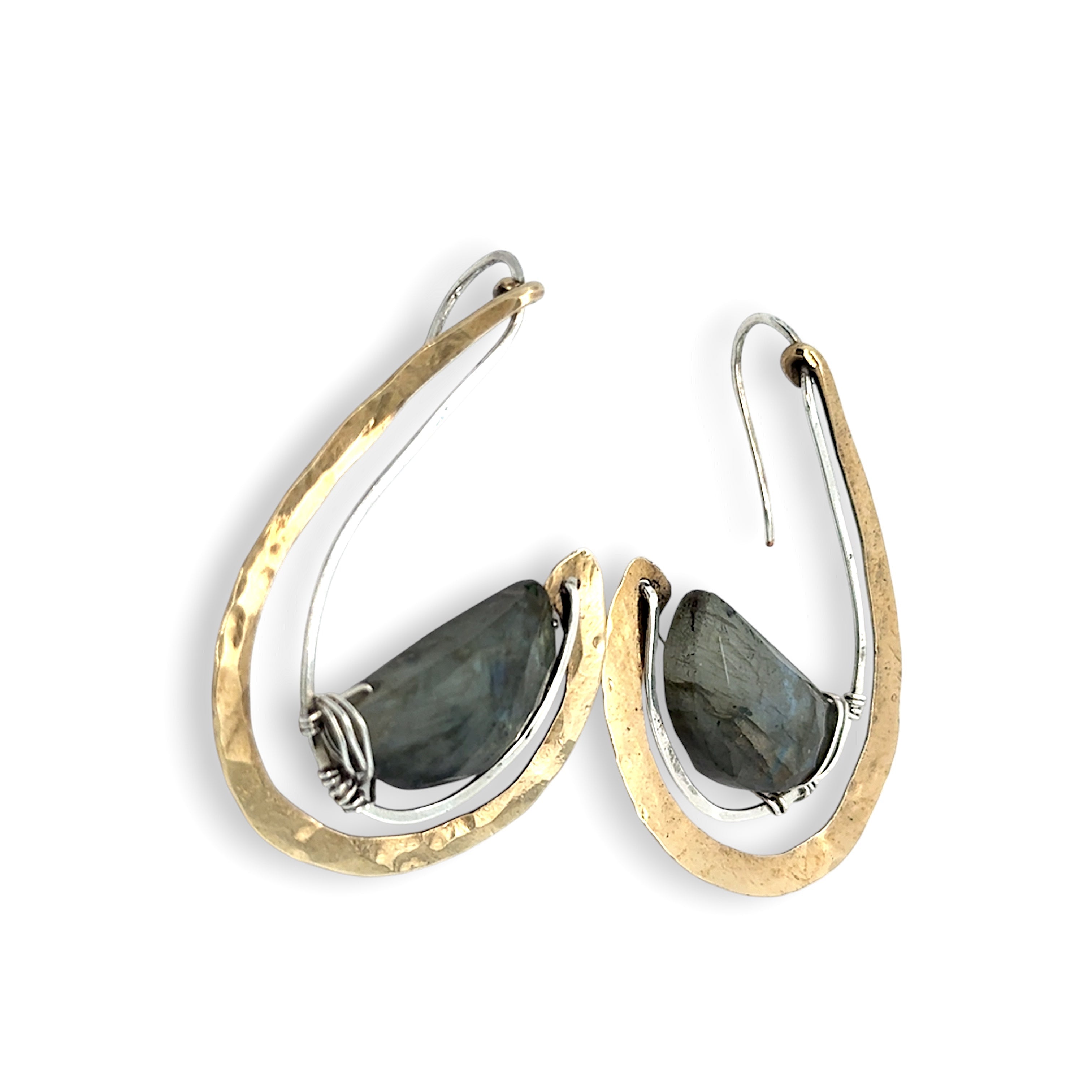 Flashy half moon shaped labradorite gemstones sitting inside a layer of sterling silver wire inside a large hammered brass hook earring with built in earring hooks to wear like a post earring