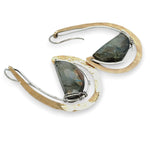 Flashy half moon shaped labradorite gemstones sitting inside a layer of sterling silver wire inside a large hammered brass hook earring with built in earring hooks to wear like a post earring