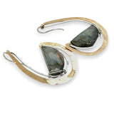 Flashy half moon shaped labradorite gemstones sitting inside a layer of sterling silver wire inside a large hammered brass hook earring with built in earring hooks to wear like a post earring