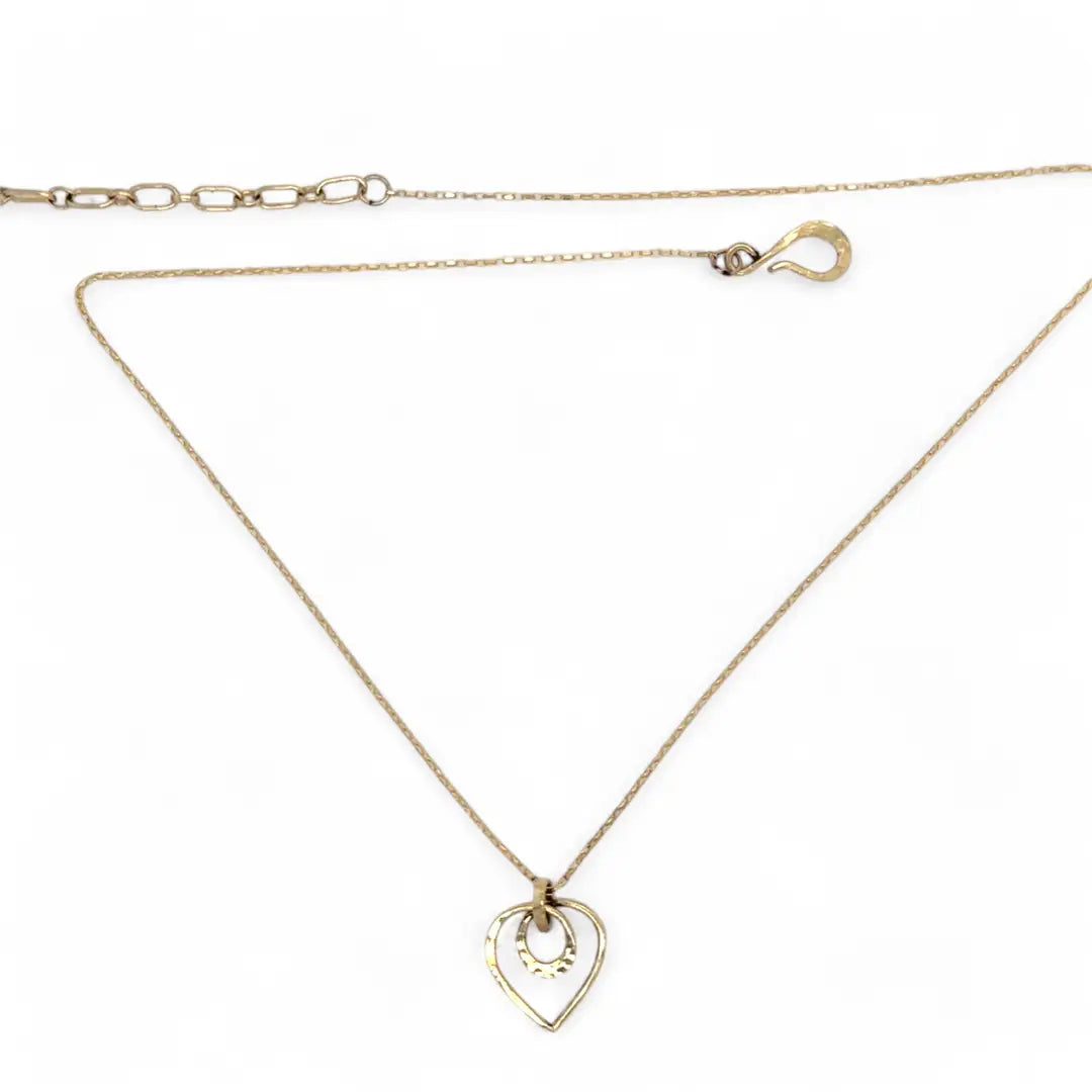 A mini gold-filled heart charm pendant necklace with a hammered texture and an adjustable delicate gold filled chain.