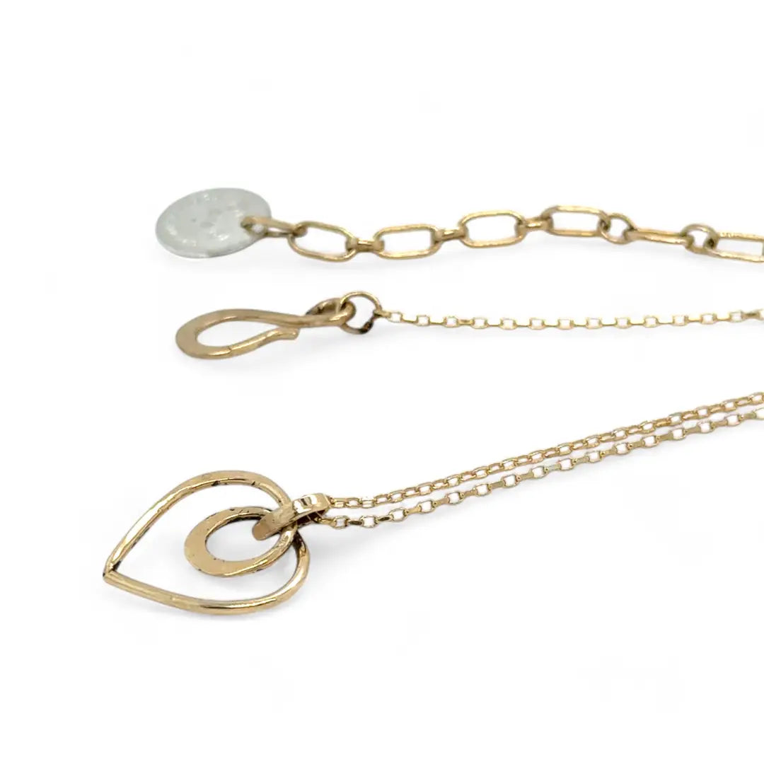A mini gold-filled heart charm pendant necklace with a hammered texture and an adjustable delicate gold filled chain.