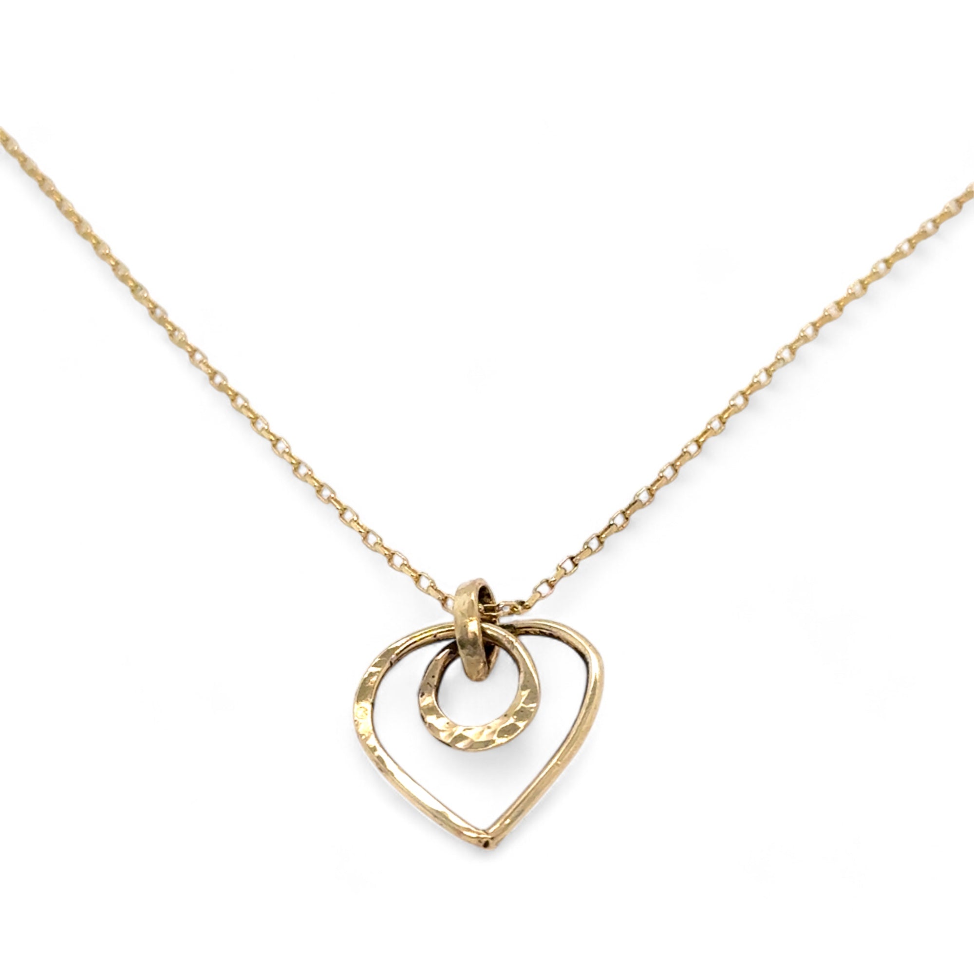 A mini gold-filled heart charm pendant necklace with a hammered texture and an adjustable delicate gold filled chain.