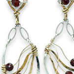 A pair of gold-filled, hammered brass and sterling silver earrings with faceted hessonite garnet gemstones, featuring sterling silver french hooks.