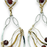 A pair of gold-filled, hammered brass and sterling silver earrings with faceted hessonite garnet gemstones, featuring sterling silver french hooks.