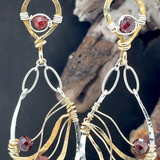 A pair of gold-filled, hammered brass and sterling silver earrings with faceted hessonite garnet gemstones, featuring sterling silver french hooks.