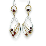 A pair of gold-filled, hammered brass and sterling silver earrings with faceted hessonite garnet gemstones, featuring sterling silver french hooks.
