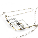 Brass and oxidized stamped sterling silver points to create a mountain scape adorned with fresh water pearl wrapped in gold filled wire on a dainty sterling silver chain necklace