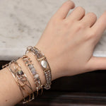 Fresh water pearl with labradorite faceted gemstones and clear quartz cubes are held within gold filled and brass wire attached to a skinny sterling silver handmade bracelet