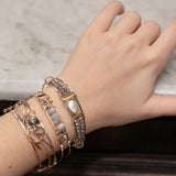 Fresh water pearl with labradorite faceted gemstones and clear quartz cubes are held within gold filled and brass wire attached to a skinny sterling silver handmade bracelet