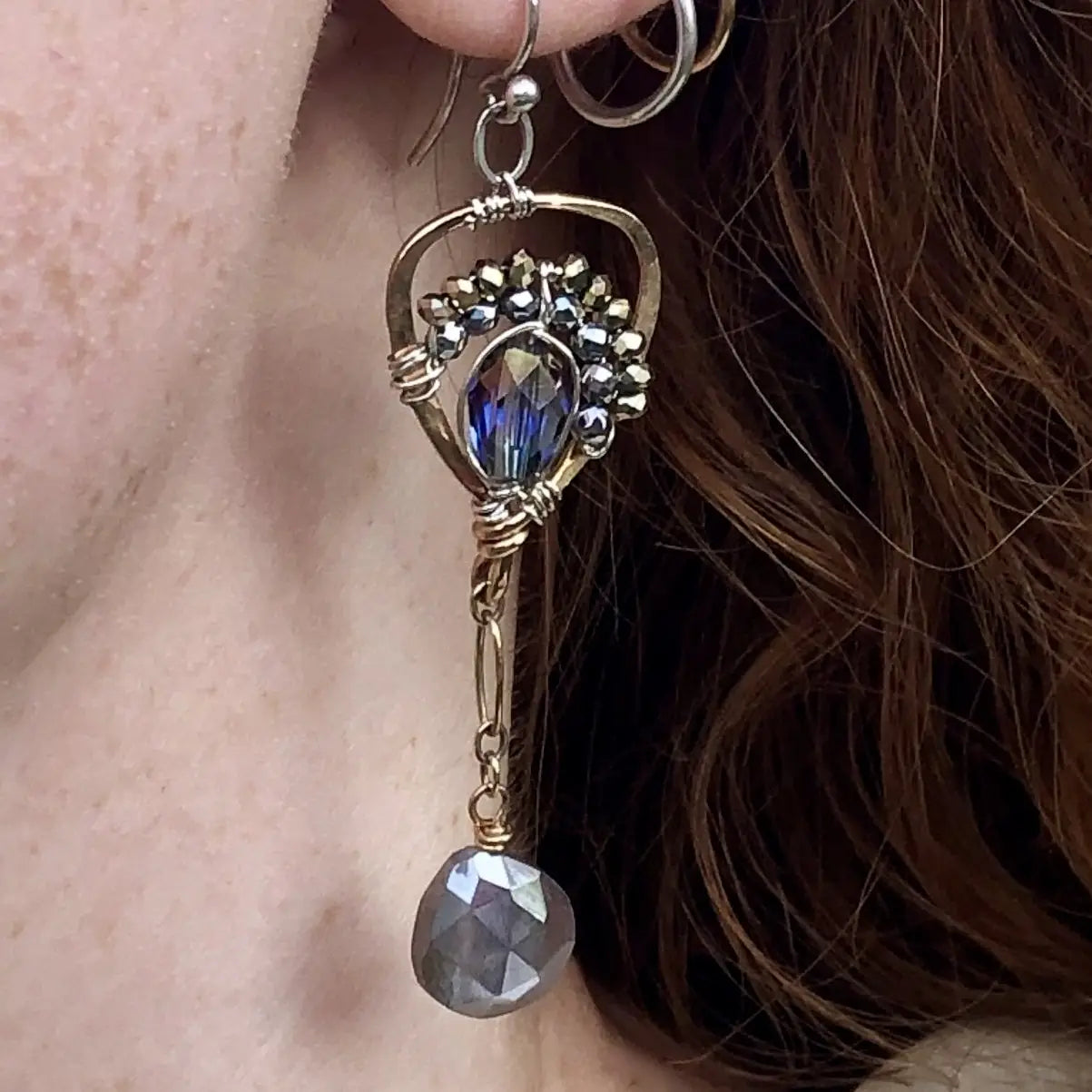 Faceted moonstone drops hang from a mini bronze hot air balloon shaped earring with blue crystal and pyrite gemstones