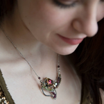 Garnet, green cubic zirconia, pyrite, and colorful crystal gemstones in oxidized stamped sterling silver wing necklace pendant with bronze accents