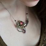 Garnet, green cubic zirconia, pyrite, and colorful crystal gemstones in oxidized stamped sterling silver wing necklace pendant with bronze accents