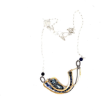 Brass statement necklace with pyrite and moonstone drops, accompanied by sodalite and pyrite gemstones laced on with sterling silver wire, accented with dark braided links within a sterling silver chain