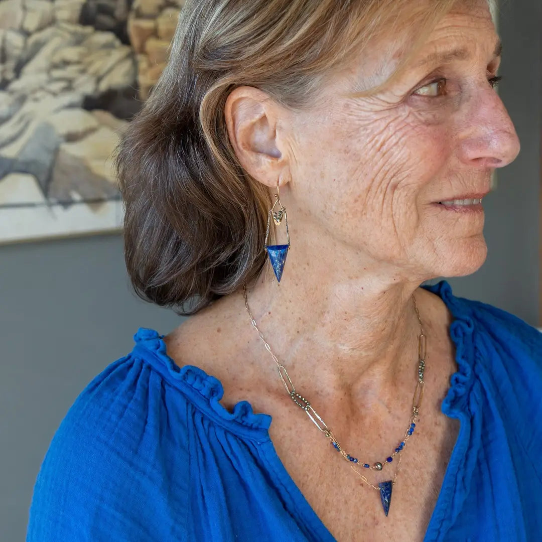 Faceted lapis triangles hang from oxidized and gold dot chain hanging from brass mini diamonds lined with pyrite earrings