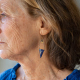 Faceted lapis triangles hang from oxidized and gold dot chain hanging from brass mini diamonds lined with pyrite earrings