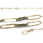Handmade brass oval links suspended between pyrite gemstones links and lapis gemstones with a lapis point on gold filled oval chain layered necklace