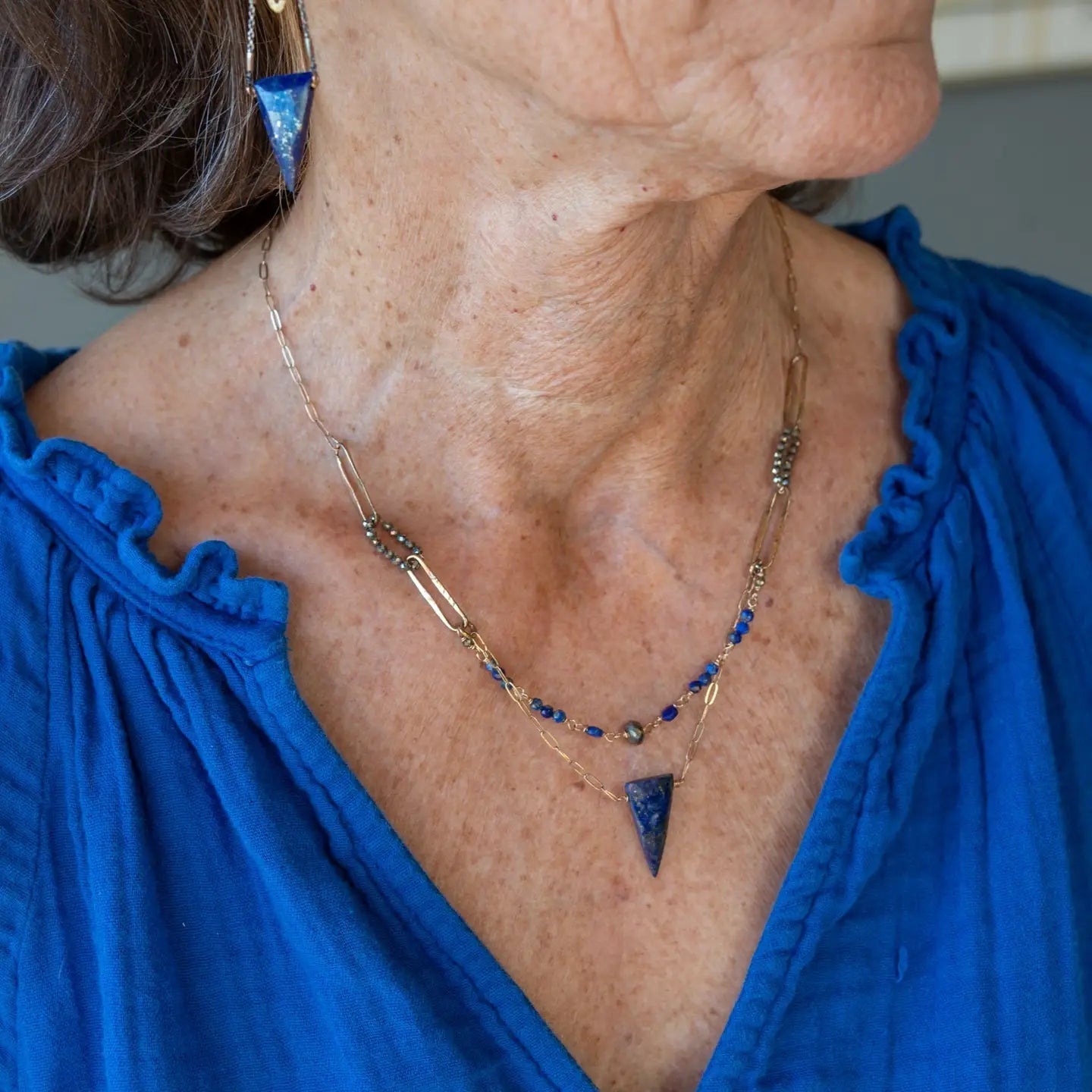 Handmade brass oval links suspended between pyrite gemstones links and lapis gemstones with a lapis point on gold filled oval chain layered necklace