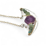 Pink tourmaline hexagon slice surrounded by green kyanite gemstones inside a hammered sterling silver boat shaped pendant, wrapped in gold fill wire with gold filled delicate chain necklace