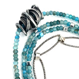 A sterling silver oxidized knot is set on layers of bright blue apatite gemstones with silver crystal cube accents, oxidized sterling diamond cut links and a dainty sterling chain necklace 