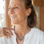 A sterling silver oxidized knot is set on layers of bright blue apatite gemstones with silver crystal cube accents, oxidized sterling diamond cut links and a dainty sterling chain necklace 