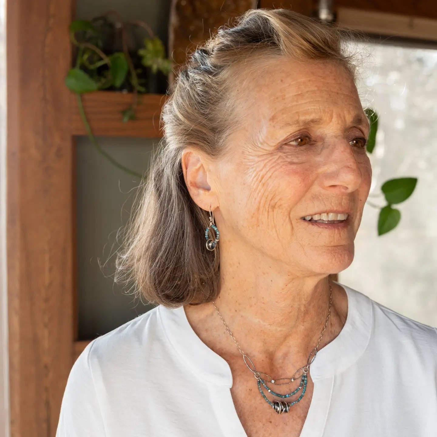 Faceted apatite gemstones form a ring that holds onto and oxidized sterling silver hand formed knot earring