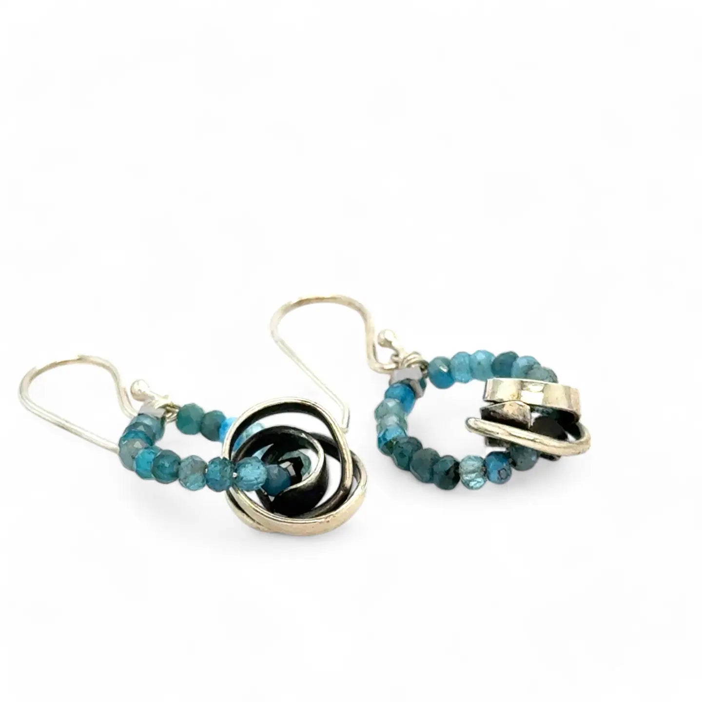 Faceted apatite gemstones form a ring that holds onto and oxidized sterling silver hand formed knot earring