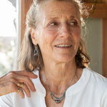 Faceted apatite gemstones form a ring that holds onto and oxidized sterling silver hand formed knot earring