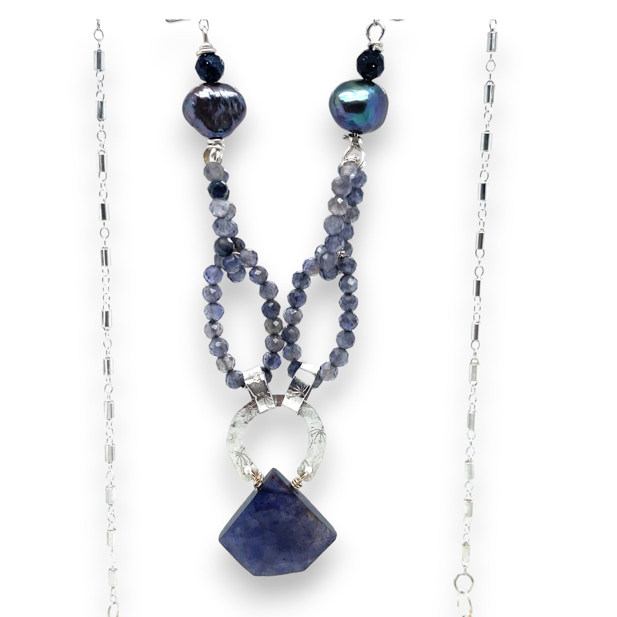 An iolite gemstone chain necklace with sterling silver hammered and stamped rings, featuring peacock freshwater pears and blue goldstone accents