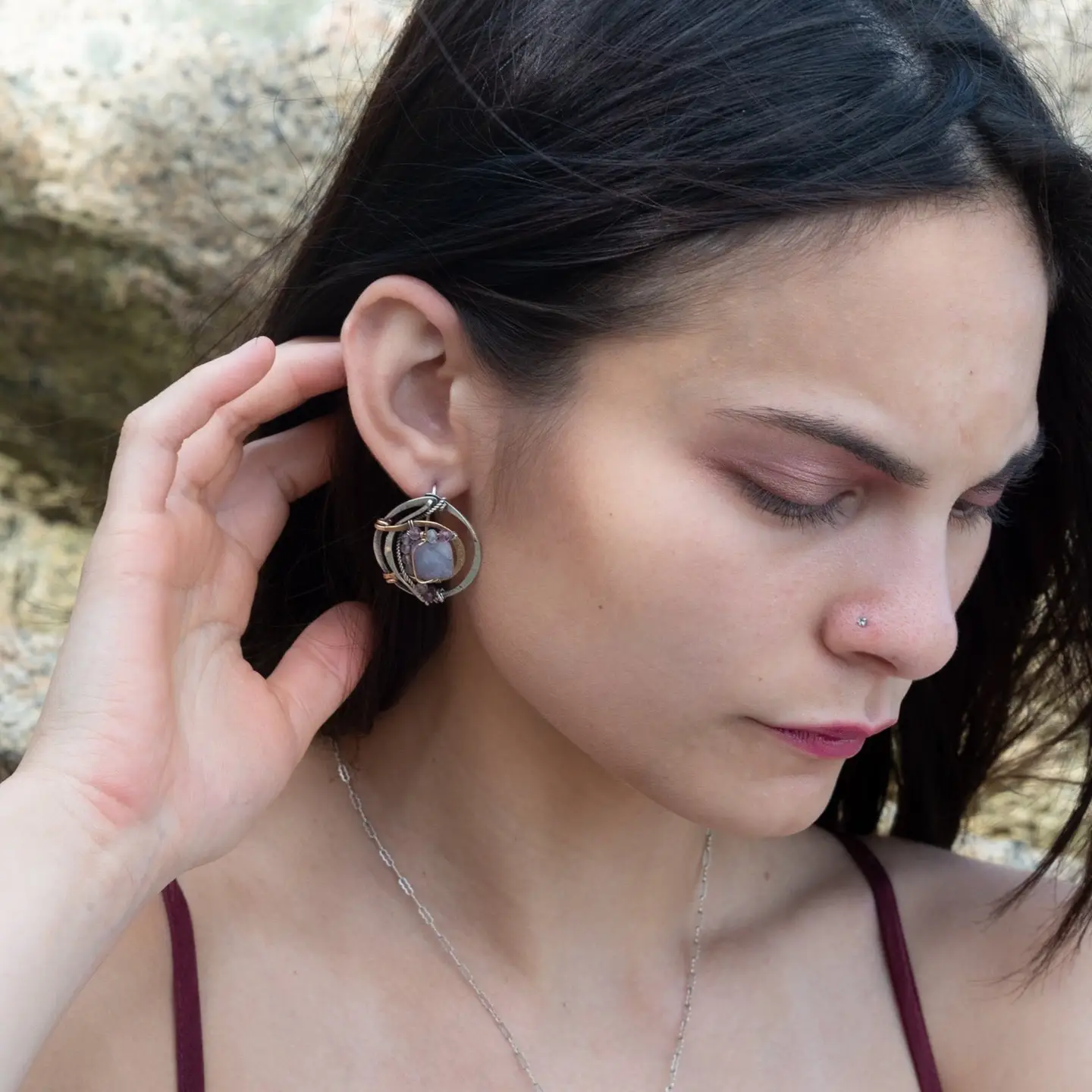 oxidized sterling silver hoops with stamped bronze and oxidized sterling twist swishes holding an iolite faceted tile and fluorite gemstones with built in earring hooks that wear like a post earrings