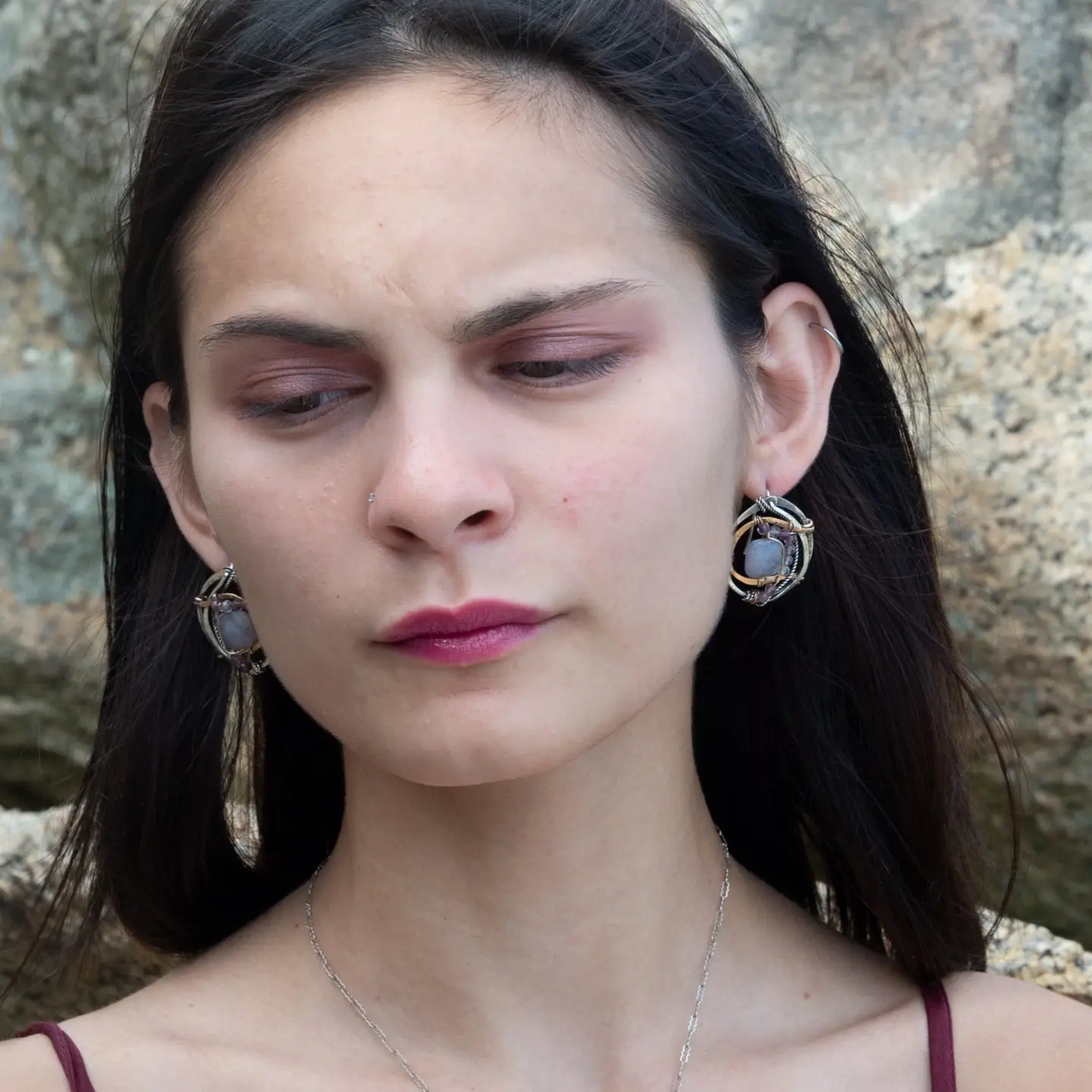 oxidized sterling silver hoops with stamped bronze and oxidized sterling twist swishes holding an iolite faceted tile and fluorite gemstones with built in earring hooks that wear like a post earrings