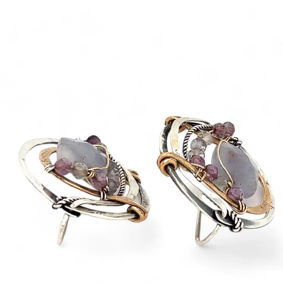 oxidized sterling silver hoops with stamped bronze and oxidized sterling twist swishes holding an iolite faceted tile and fluorite gemstones with built in earring hooks that wear like a post earrings