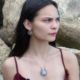 oxidized sterling silver hoops with stamped bronze and oxidized sterling twist swishes holding an iolite faceted tile and fluorite gemstones with built in earring hooks that wear like a post earrings