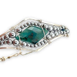 double pointed chrysocolla gemstone center wrapped in varying sizes of smooth pyrite ball gemstones in a sterling silver cuff bracelet