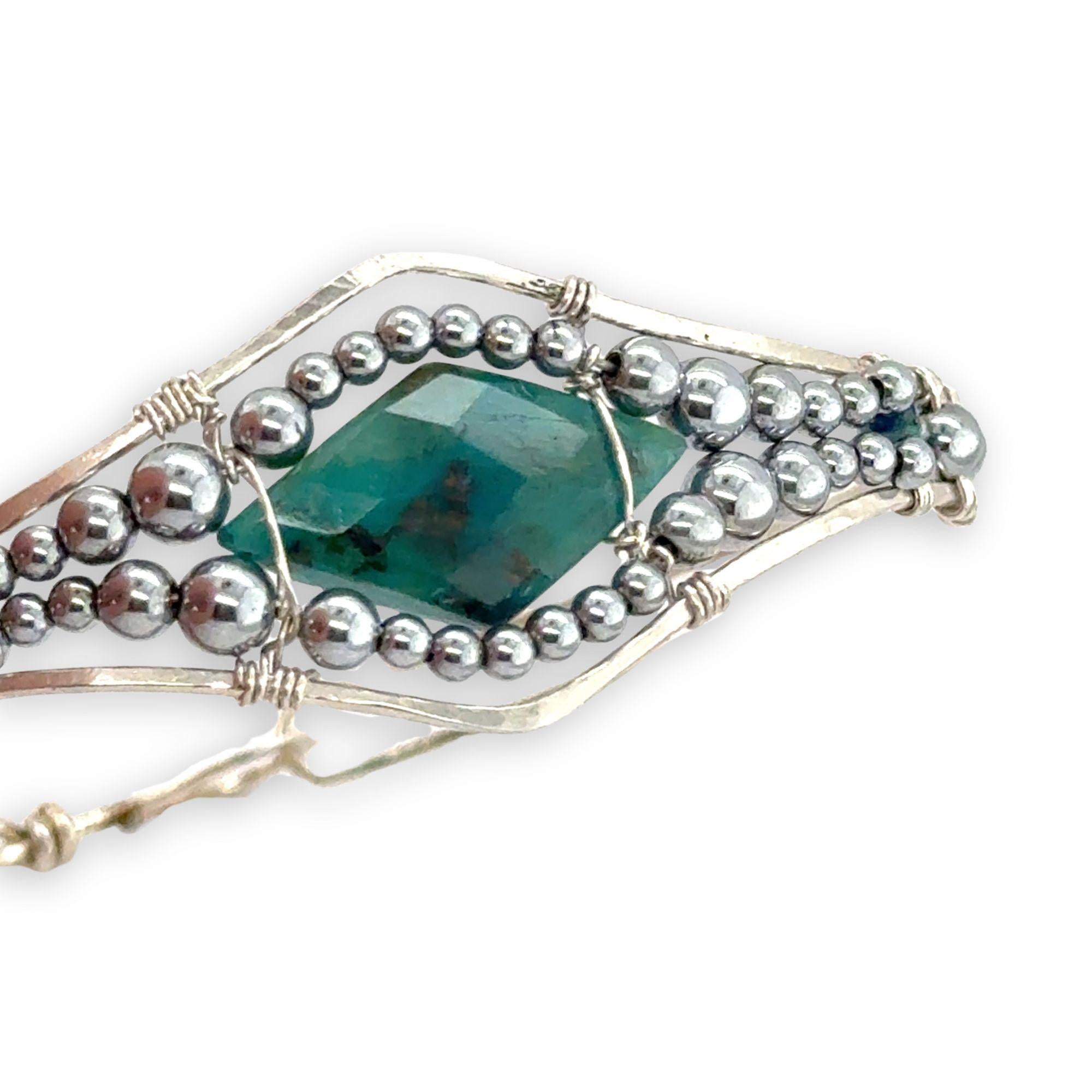 double pointed chrysocolla gemstone center wrapped in varying sizes of smooth pyrite ball gemstones in a sterling silver cuff bracelet