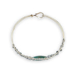 double pointed chrysocolla gemstone center wrapped in varying sizes of smooth pyrite ball gemstones in a sterling silver cuff bracelet