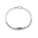 double pointed chrysocolla gemstone center wrapped in varying sizes of smooth pyrite ball gemstones in a sterling silver cuff bracelet