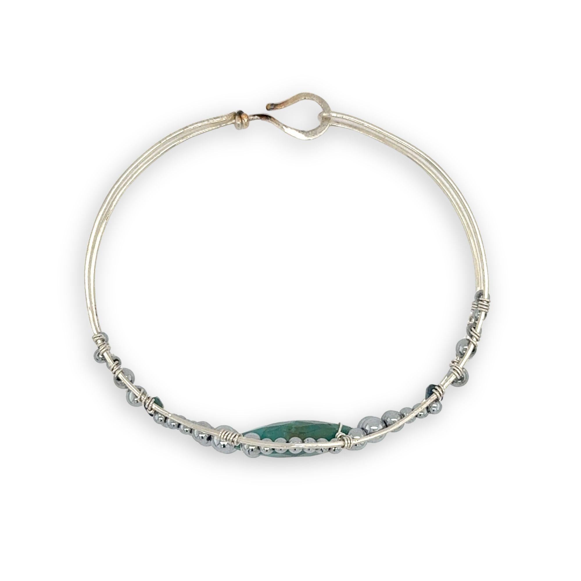 double pointed chrysocolla gemstone center wrapped in varying sizes of smooth pyrite ball gemstones in a sterling silver cuff bracelet