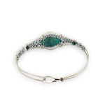 double pointed chrysocolla gemstone center wrapped in varying sizes of smooth pyrite ball gemstones in a sterling silver cuff bracelet