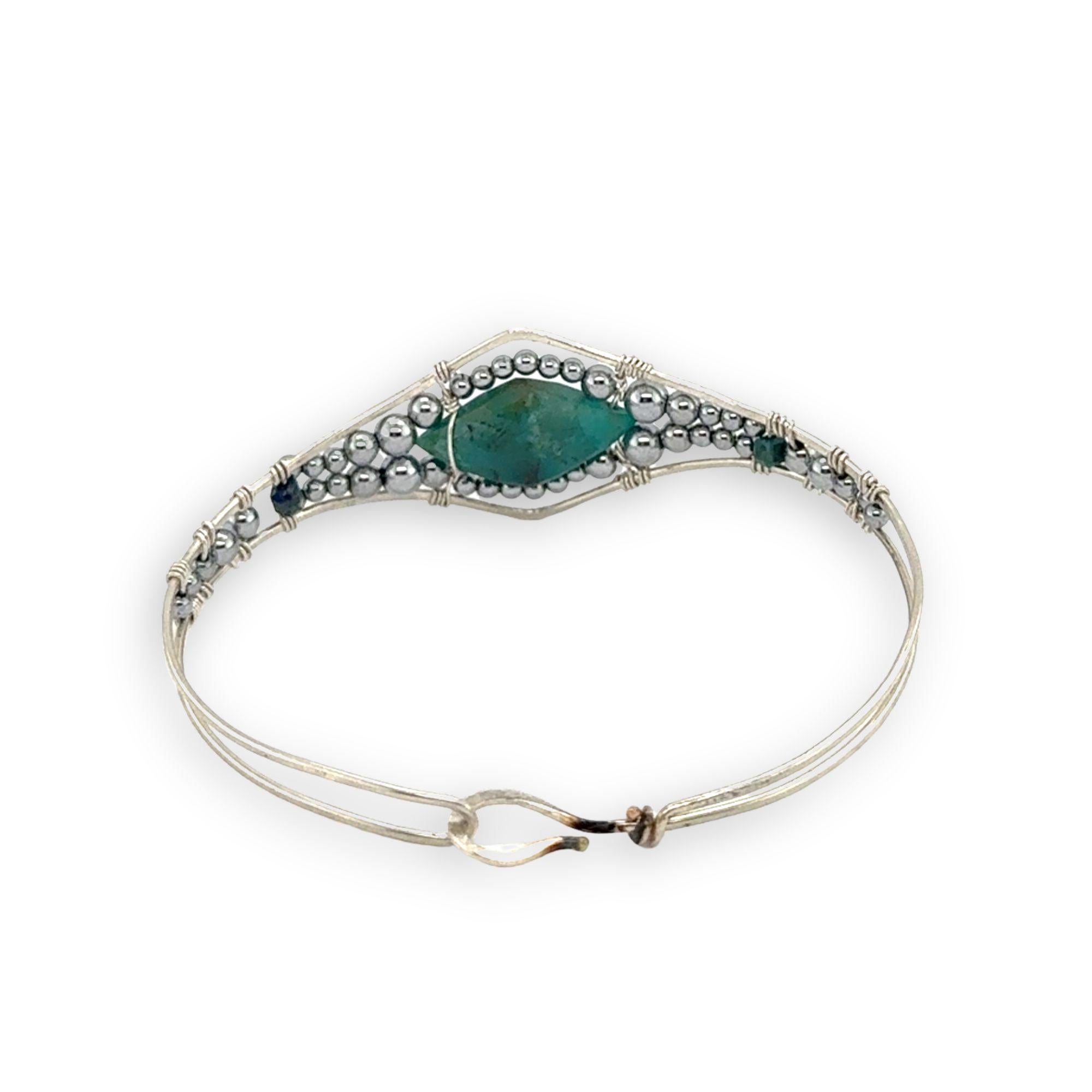 double pointed chrysocolla gemstone center wrapped in varying sizes of smooth pyrite ball gemstones in a sterling silver cuff bracelet