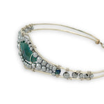 double pointed chrysocolla gemstone center wrapped in varying sizes of smooth pyrite ball gemstones in a sterling silver cuff bracelet