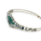 double pointed chrysocolla gemstone center wrapped in varying sizes of smooth pyrite ball gemstones in a sterling silver cuff bracelet