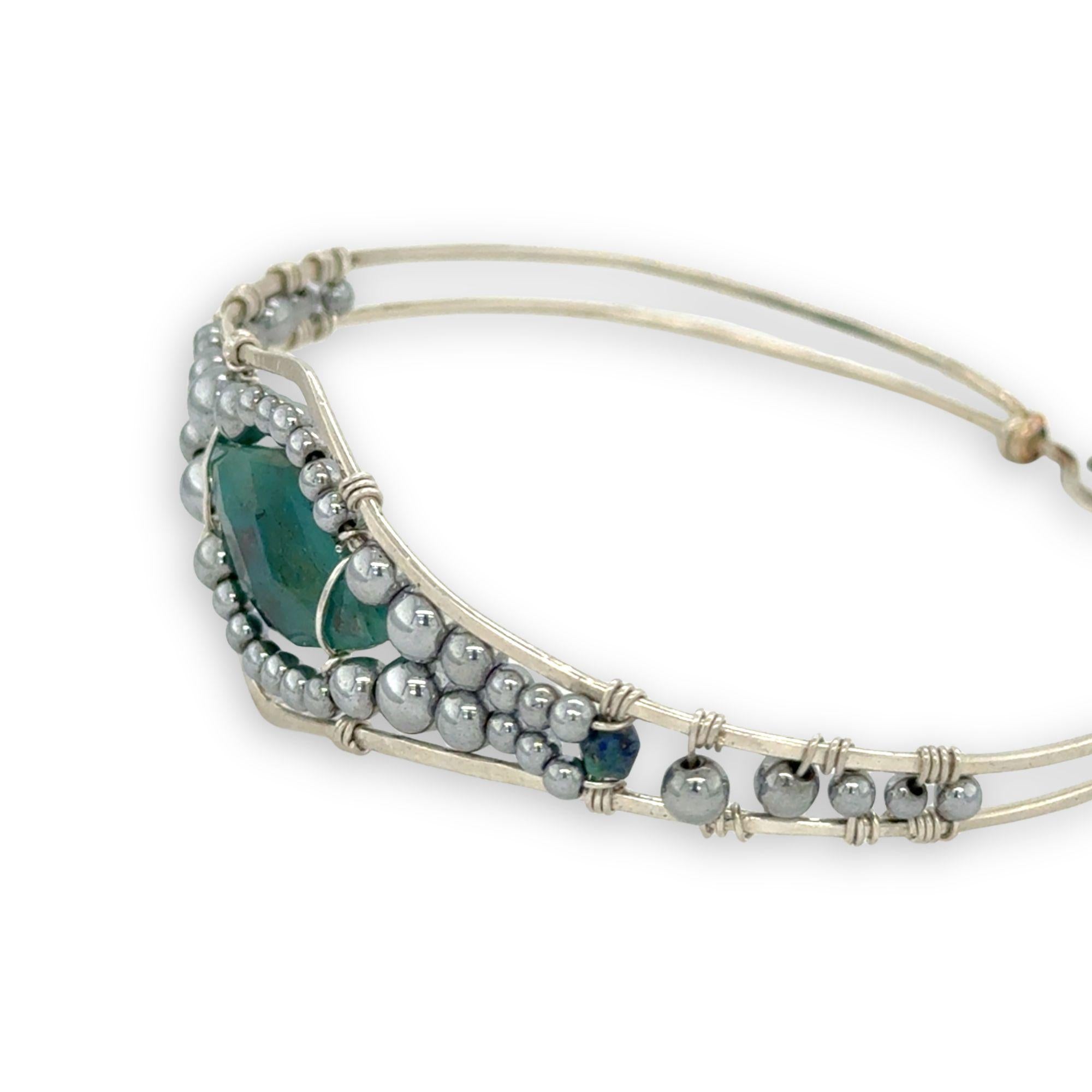 double pointed chrysocolla gemstone center wrapped in varying sizes of smooth pyrite ball gemstones in a sterling silver cuff bracelet