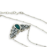 Necklace with sterling silver wings shaped pendant featuring a chrysocolla gemstone and smooth pyrite gemstones 