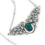 Necklace with sterling silver wings shaped pendant featuring a chrysocolla gemstone and smooth pyrite gemstones 