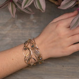 moss agate, green amethyst, and crystal gemstones are braided within waves of hammered brass, bronze, and sterling silver to form a braided cuff bracelet