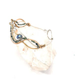 moss agate, green amethyst, and crystal gemstones are braided within waves of hammered brass, bronze, and sterling silver to form a braided cuff bracelet