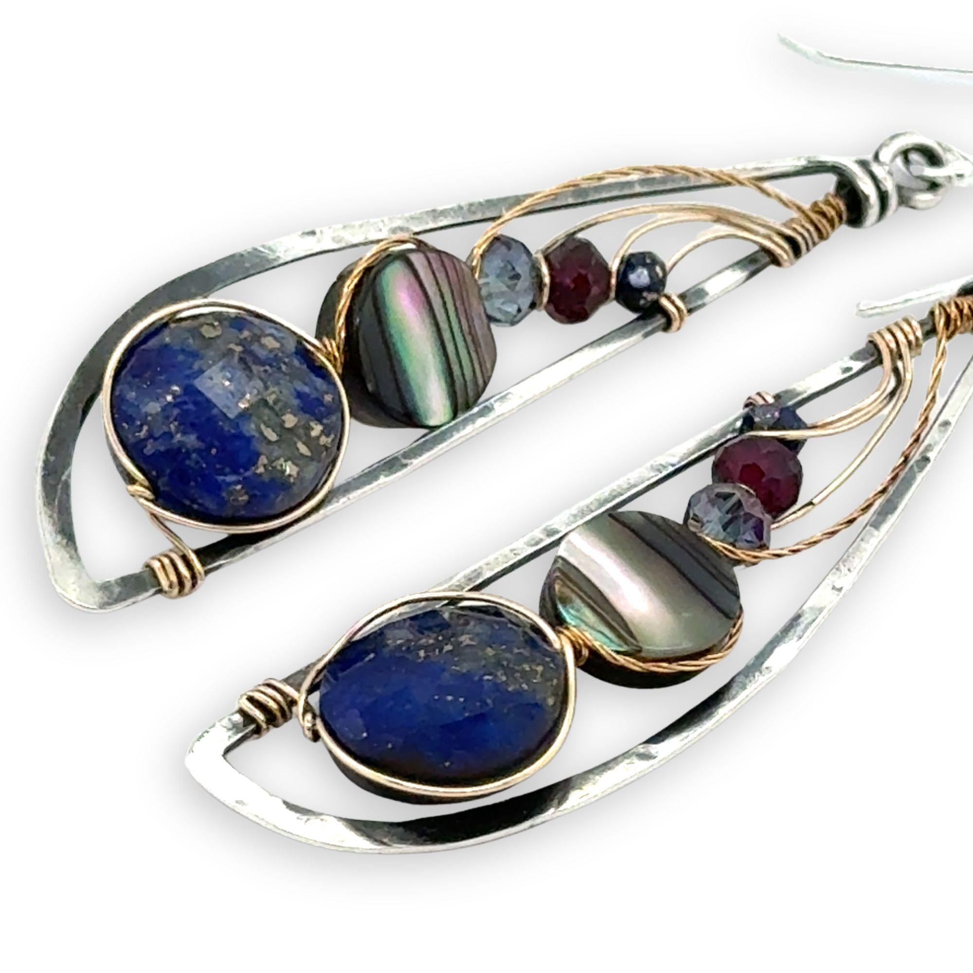 Darkened sterling silver hammered wing shaped earrings with lapis, abalone, crystal, and garnet gemstones wrapped in gold filled and brass twist wires