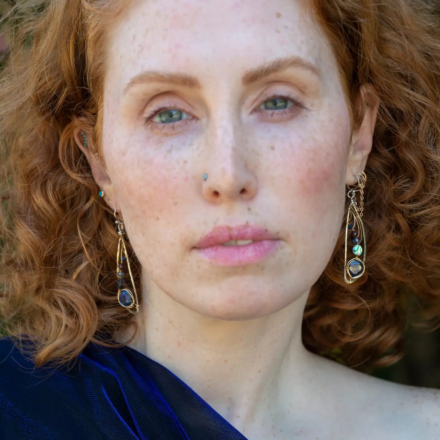 Darkened sterling silver hammered wing shaped earrings with lapis, abalone, crystal, and garnet gemstones wrapped in gold filled and brass twist wires