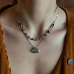 a flashy labradorite an gemstone is held on oxidized sterling silver dot chain with a second layer of cat's eye gemstones and fresh water pearl necklace